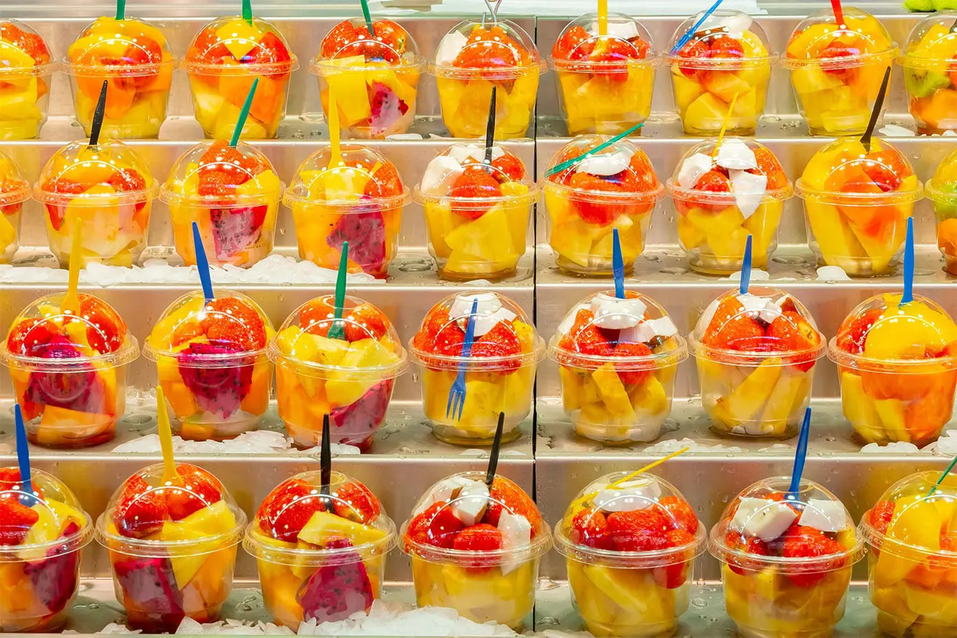 image of fresh cut pineapple chunks in a to go container on a refrigerated shelf in the grocery store.