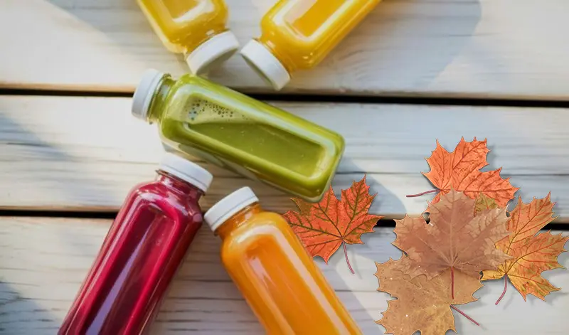 Fruit Juice on a picnic table in fall with leaves on the table